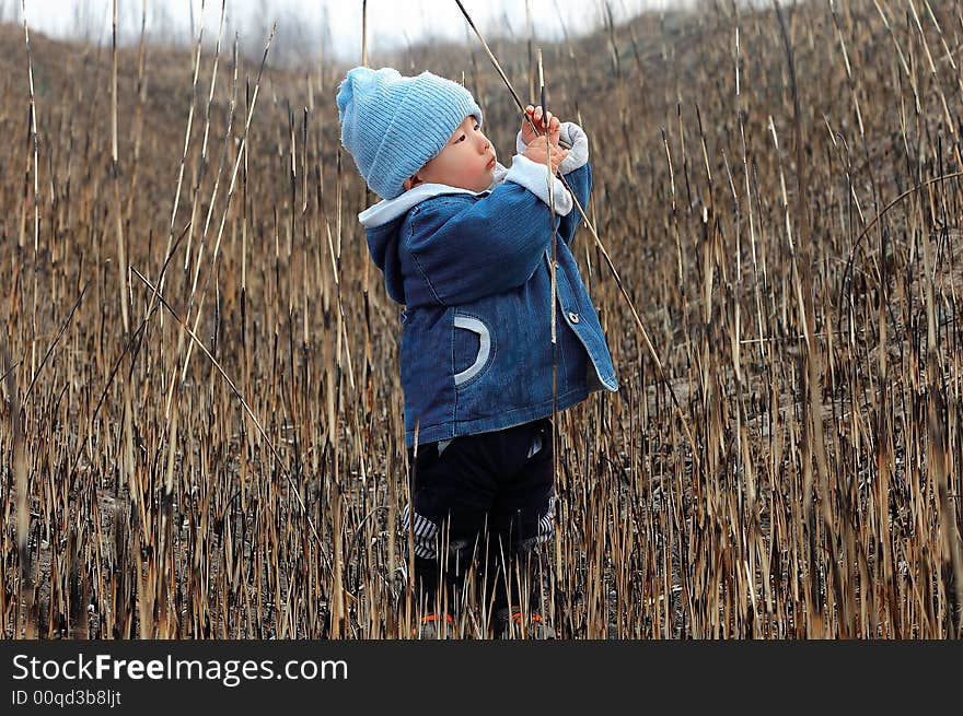 A baby playing in the winter grass field. A baby playing in the winter grass field