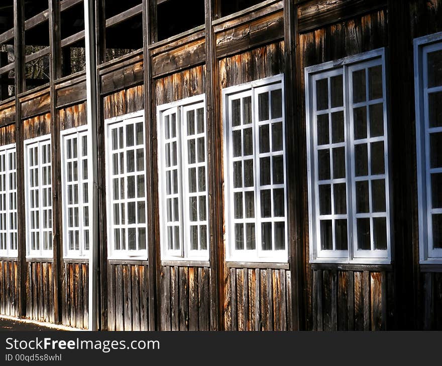 Row of old windows in a old wood plank building. Row of old windows in a old wood plank building.