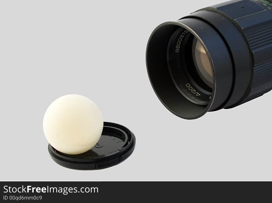 Old objective and ball on lens cover isolated on gray