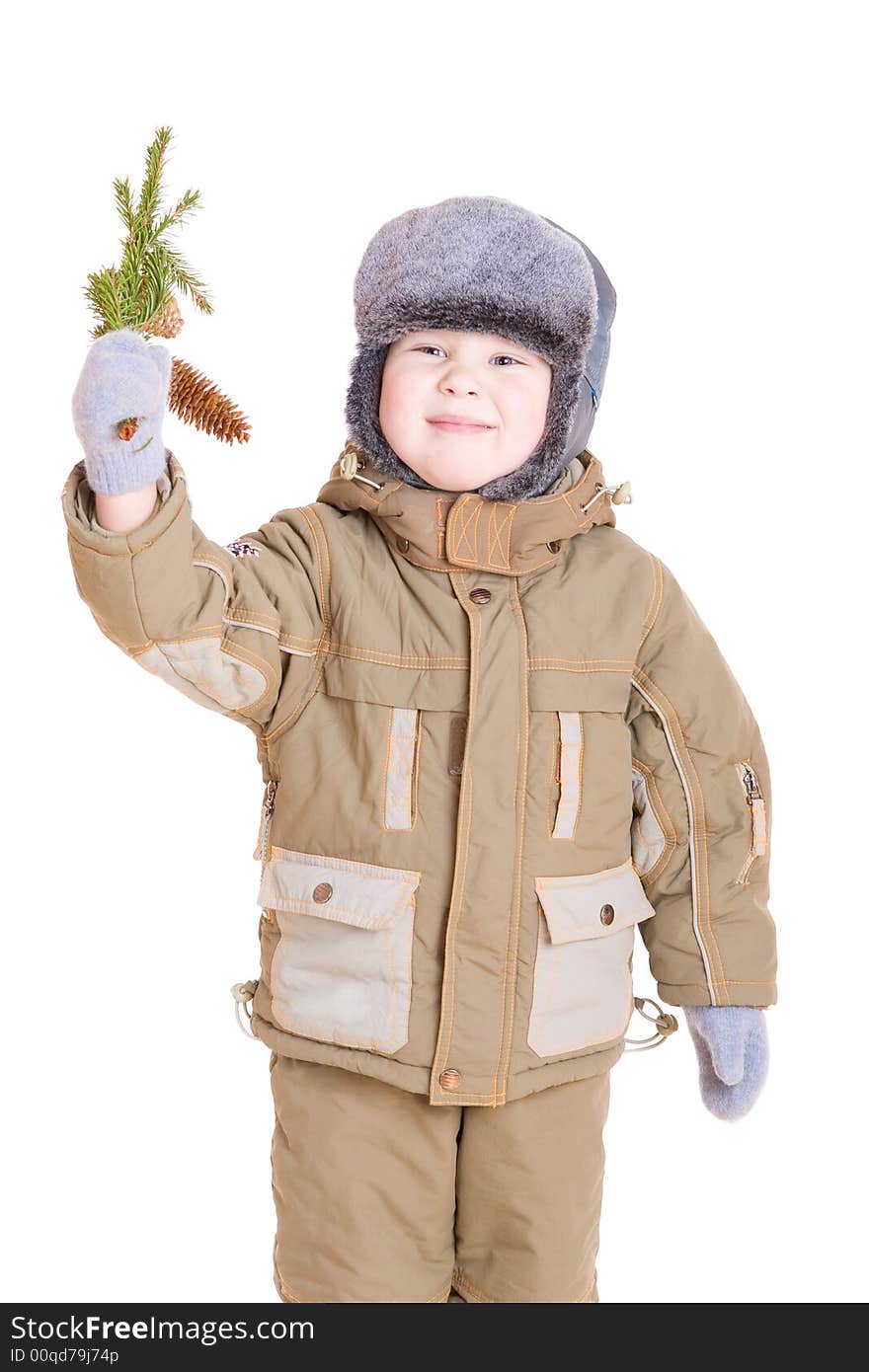 A smiling boy dressed for winter with a branch of fur tree with cones. A smiling boy dressed for winter with a branch of fur tree with cones