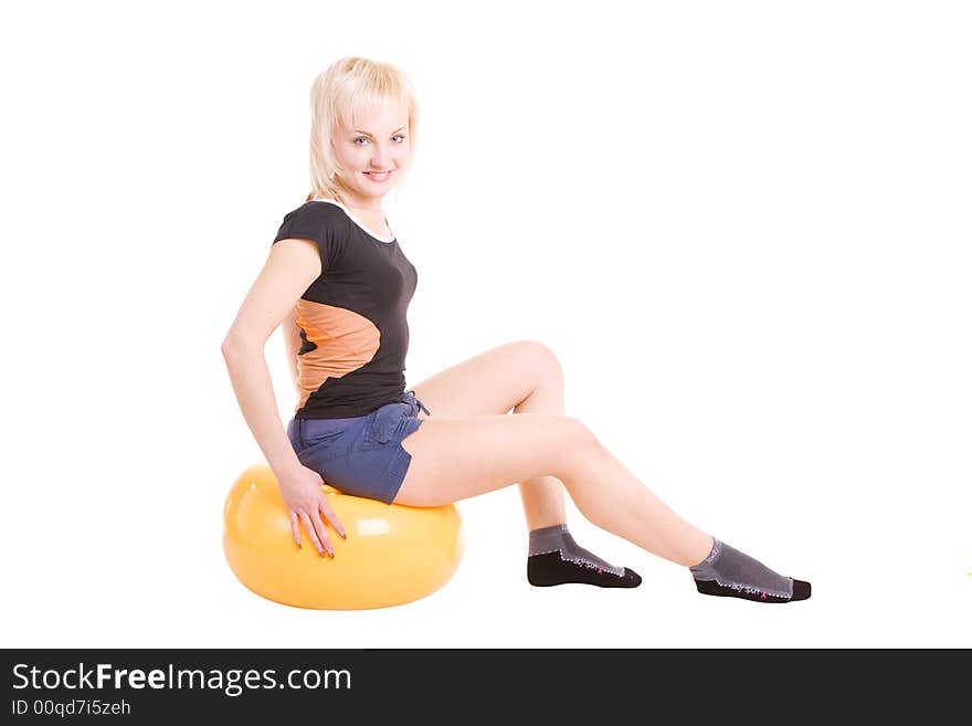 A young girl sitting on the big ball for fitness