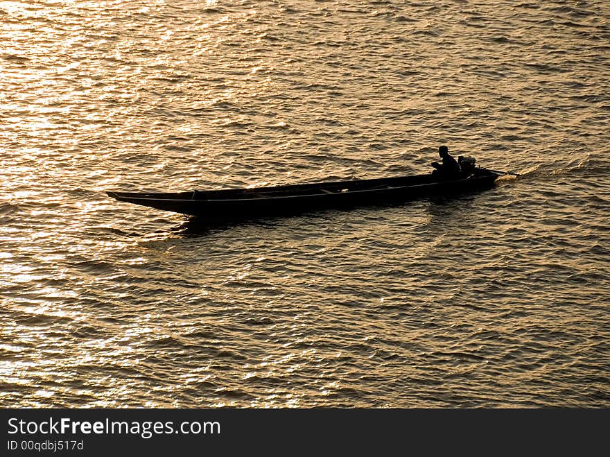 Small riverboat silhouette on a river