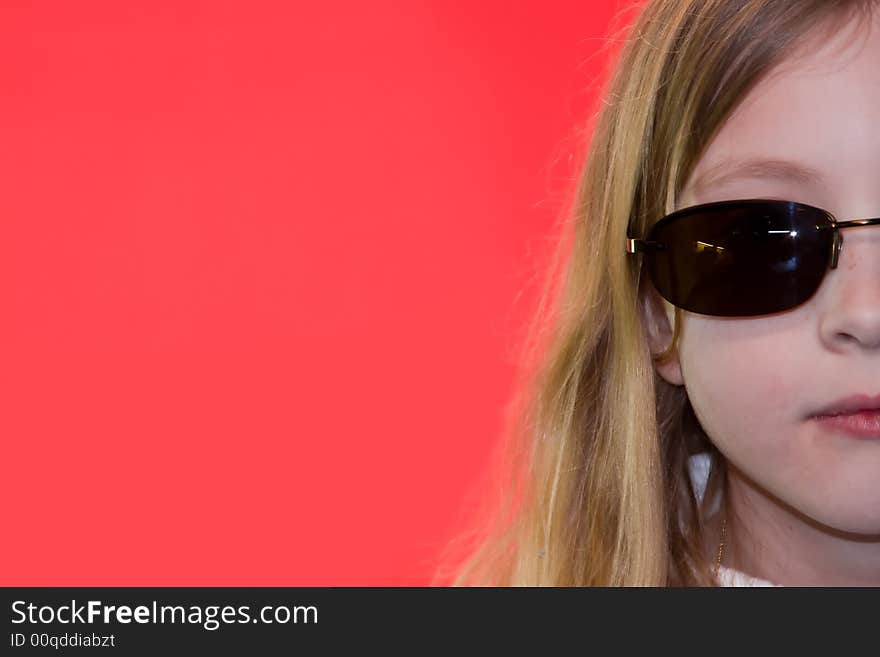 Blonde girl wearing sunglasses on pink background