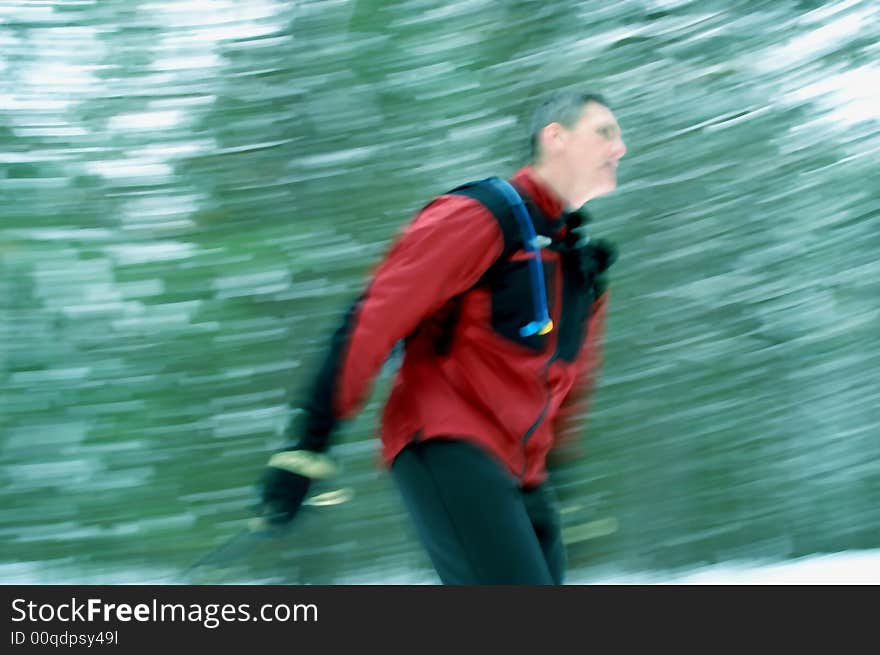 Nordic skate-skier blazes through coniferous forest in central Ontario. Nordic skate-skier blazes through coniferous forest in central Ontario.