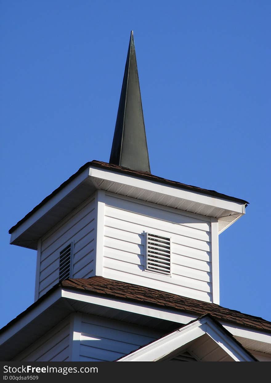 Pointed church steeple against blue sky. Pointed church steeple against blue sky.