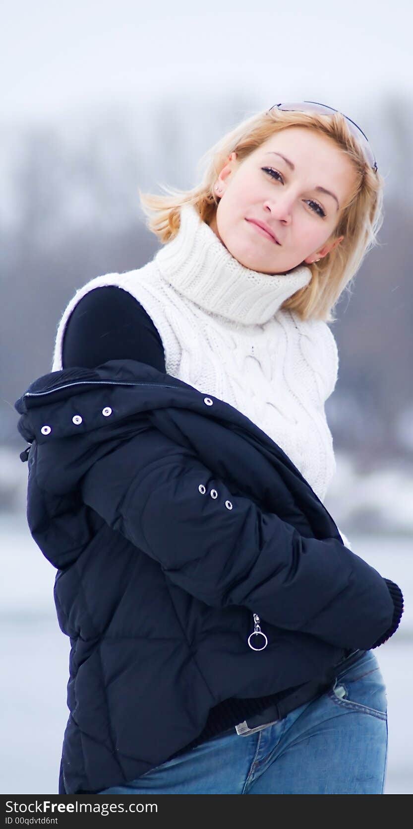 Woman with winter jacket against a background of frozen river