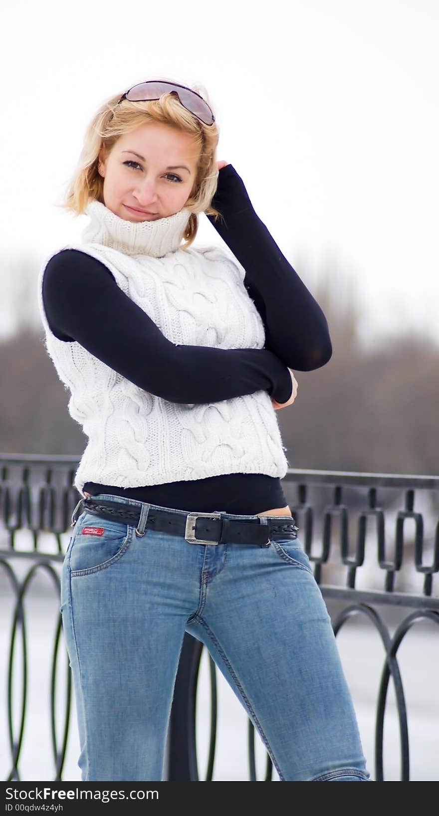 Young girl in white sweater against a background of forzen river