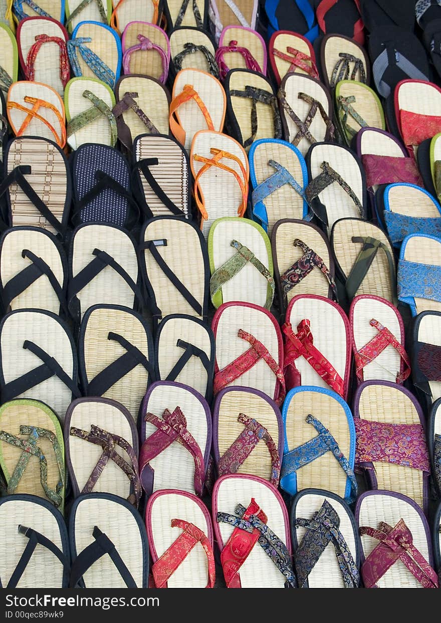 Lots of sandals in a market, many with Chinese style silk fabrics, all for the right foot.