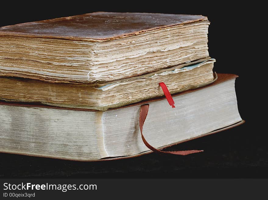 Three worn and weathered leather bound books on black background. Three worn and weathered leather bound books on black background.