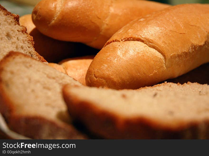 Rolls and slices of bread on the kitchen table ready to be served. Rolls and slices of bread on the kitchen table ready to be served