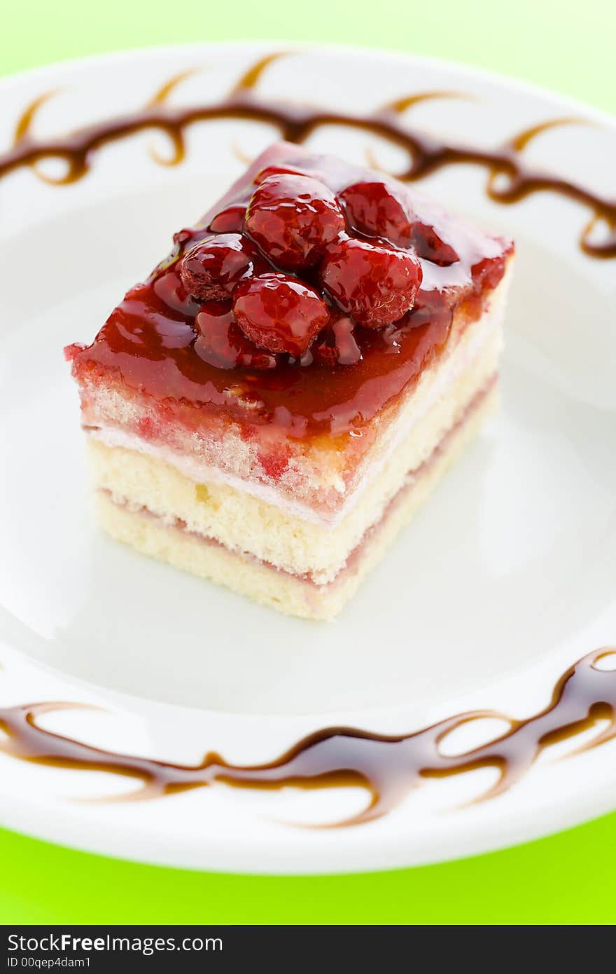 Piece of raspberry cake on the plate with chocolate dressing