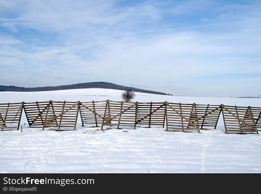 He is a snow-fence on a snowy tillage. He is a snow-fence on a snowy tillage.