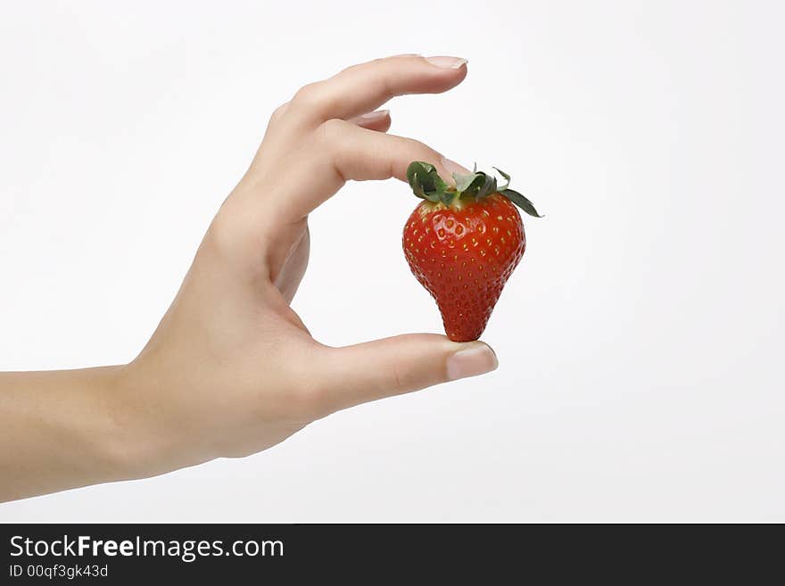 Closeup shot of one strawberry in womans fingers. Closeup shot of one strawberry in womans fingers