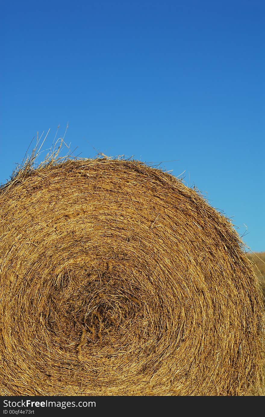 Round Bale Of Hay And Blue Sky