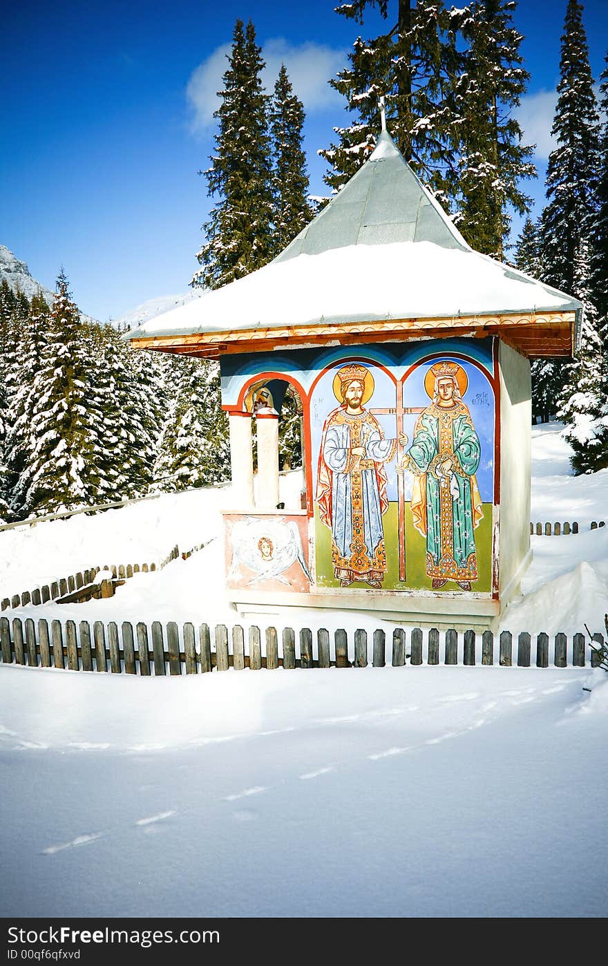 Traditional romanian orthodox christian painted  trinity in a rural, woodland snowy landscape, prayer concept