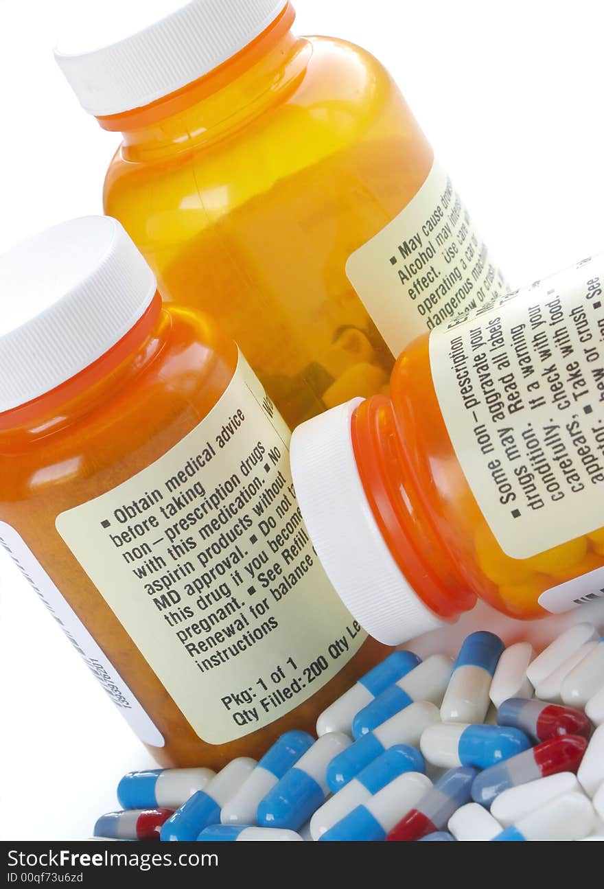 Bottles of Pills Surrounded by Capsules on White Background. Bottles of Pills Surrounded by Capsules on White Background