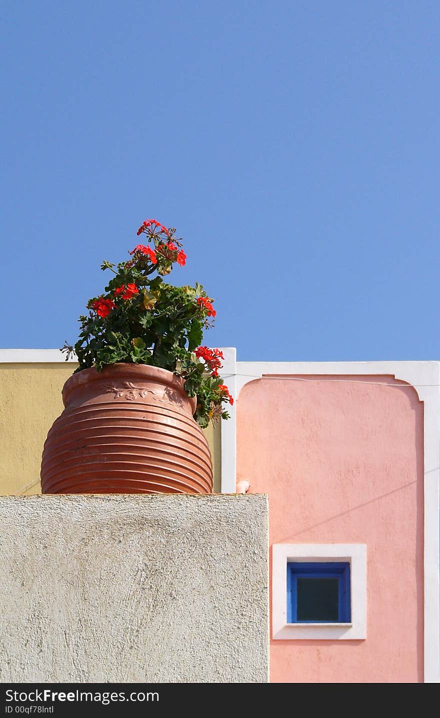 Flower-pot with pelargonium and small window in Santorini in Greece