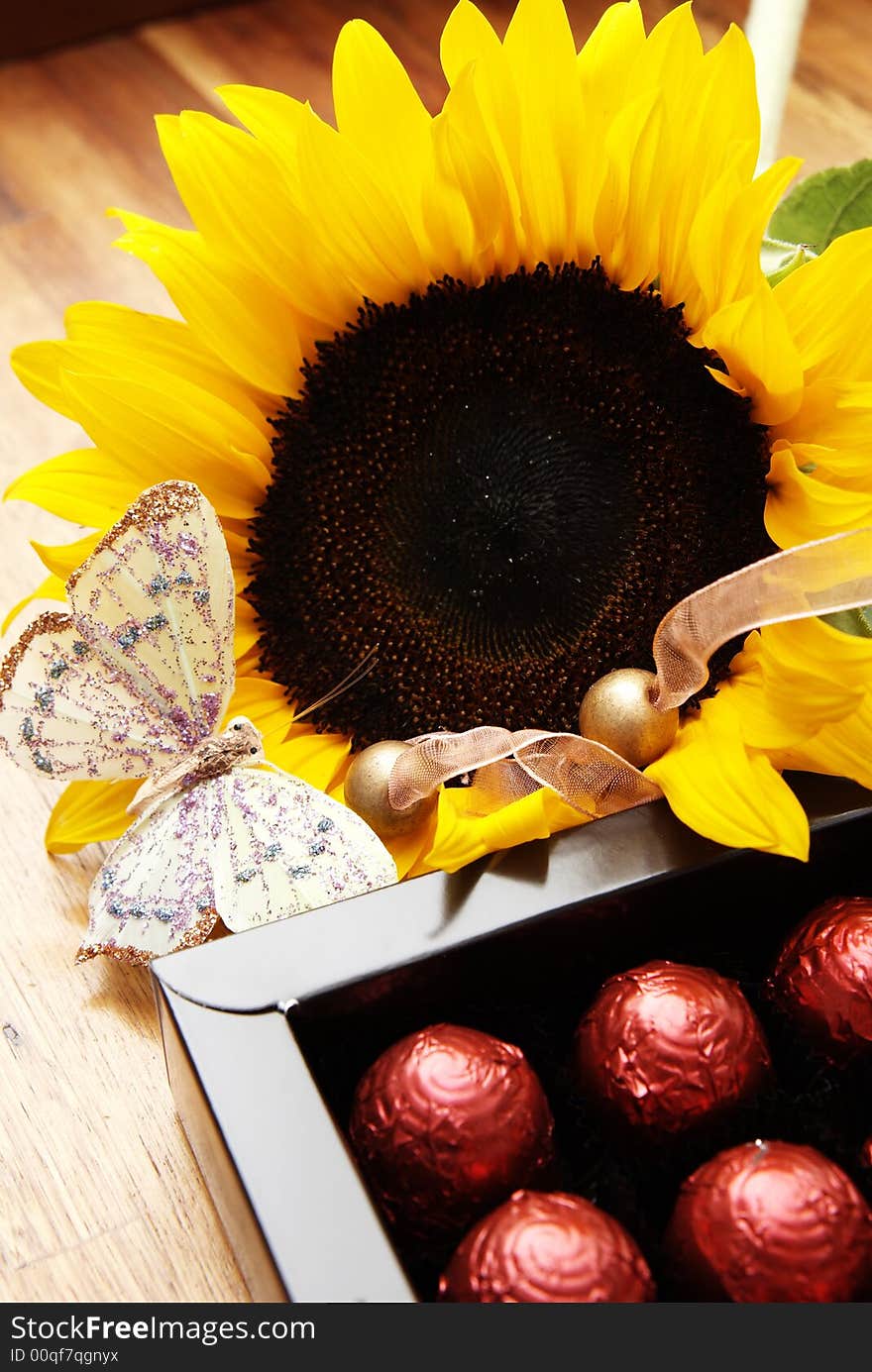 Sunflower, butterfly and chocolate balls in a box