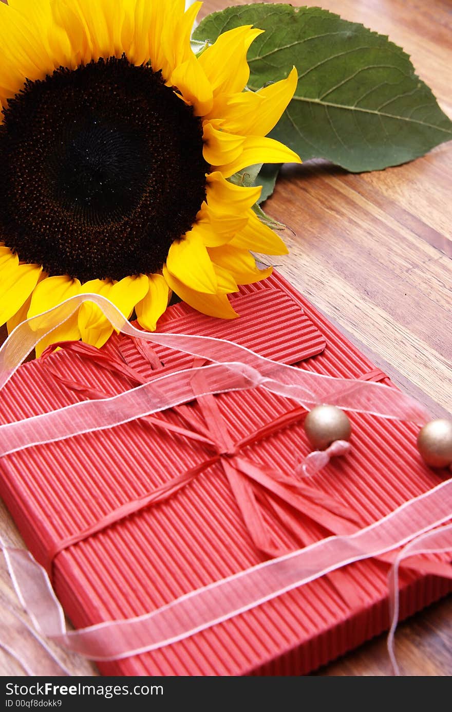 Sunflower, butterfly and a red box on a wooden table
