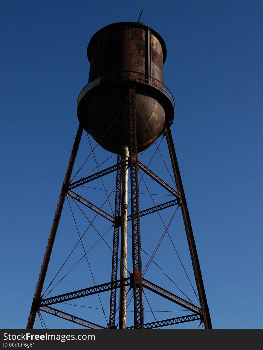 Old rusted water tower against a blue sky. Old rusted water tower against a blue sky