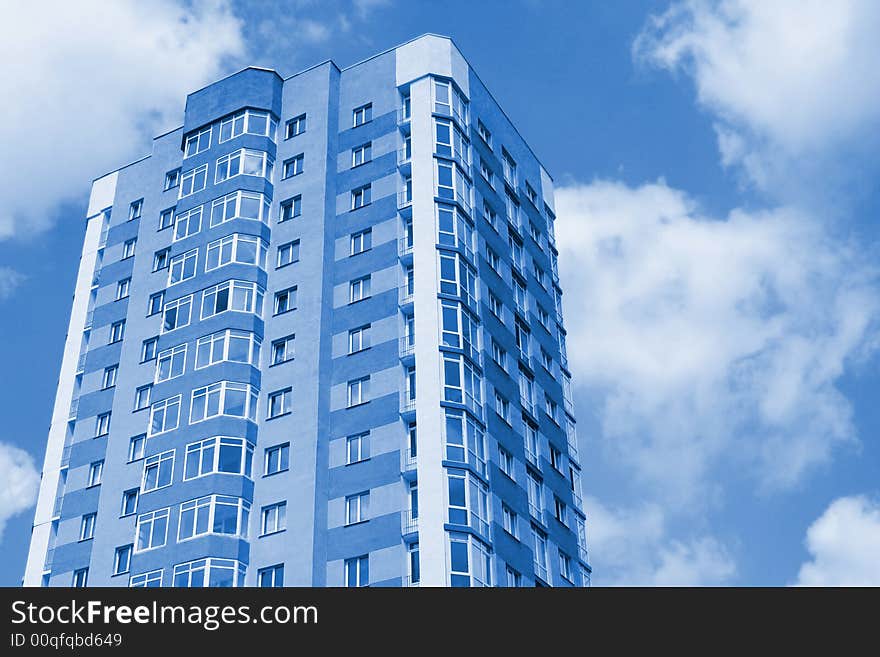 Modern city building against sky. Blue colored image.