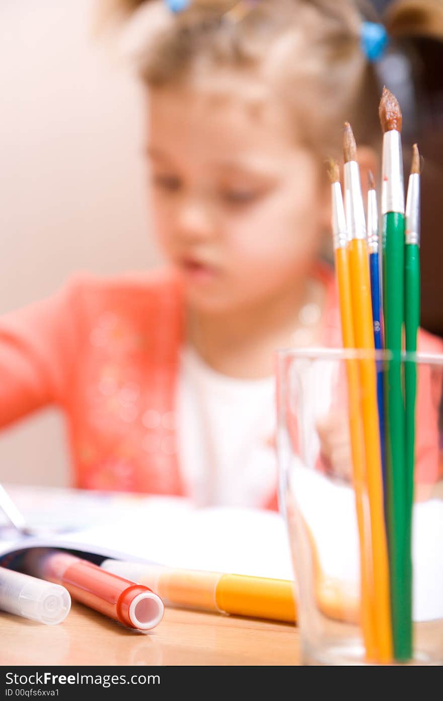 Close-up watercolor brush and little girl