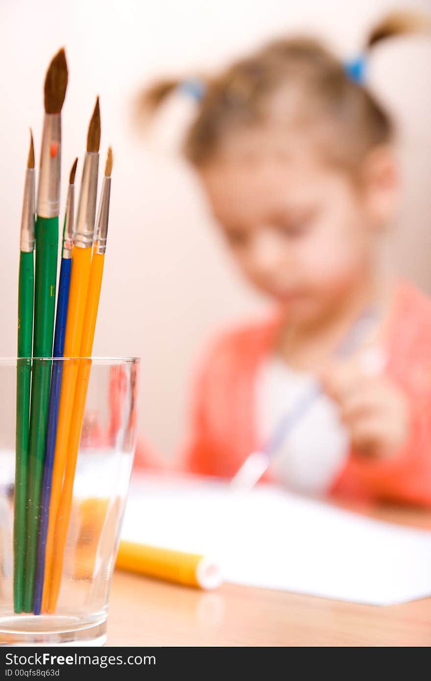 Close-up watercolor brush and little girl