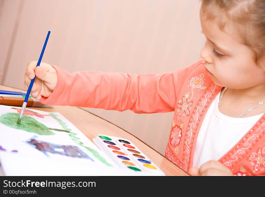 Pretty caucasian child watercolor paint . Focus point on a hand.