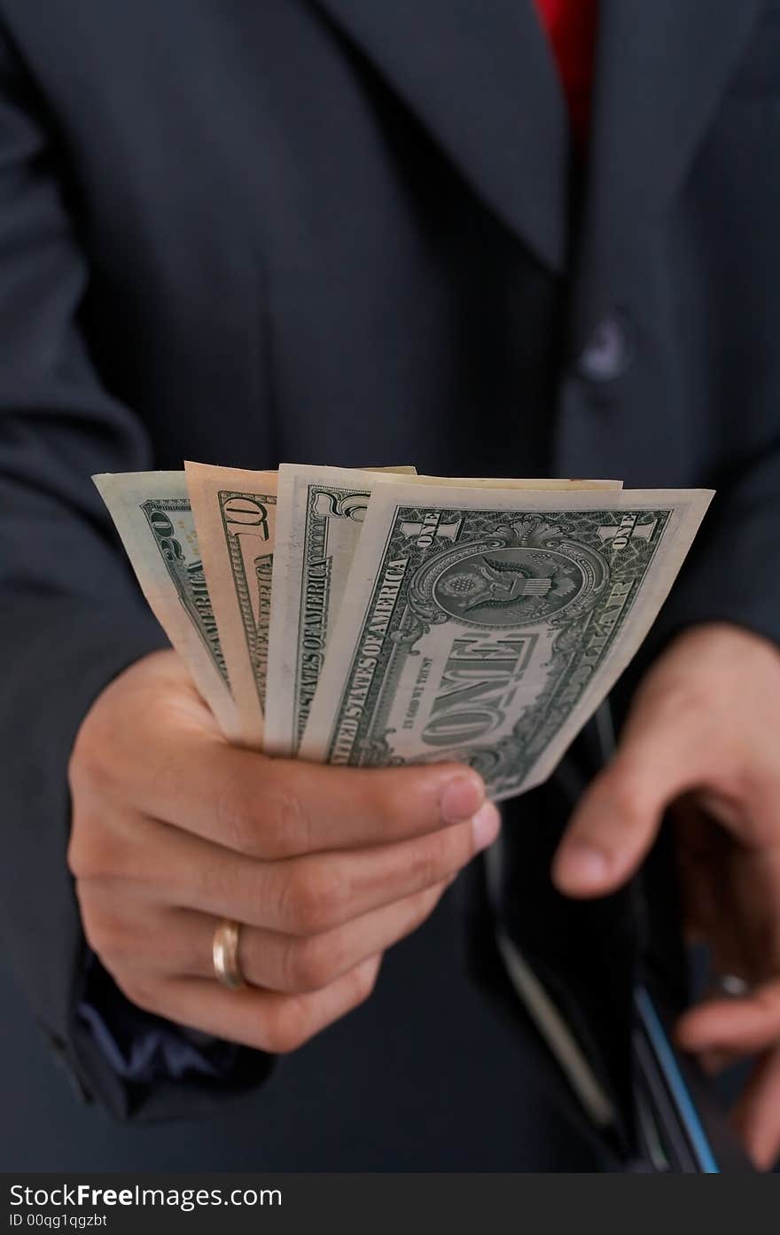 A businessman holding a wallet with dollar bills