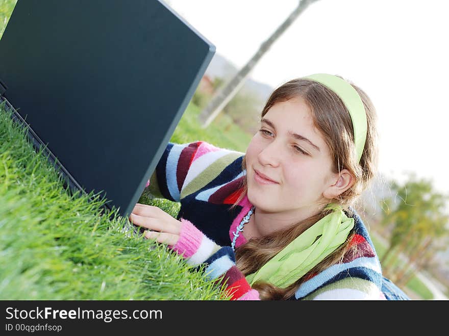 Young girl is working on laptop at outdoor location. Young girl is working on laptop at outdoor location