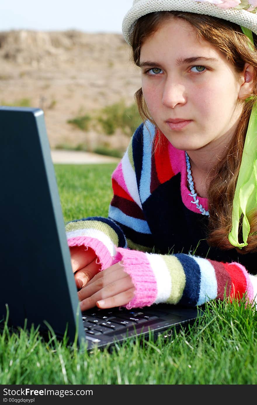 Young girl is working on laptop at outdoor location. Young girl is working on laptop at outdoor location