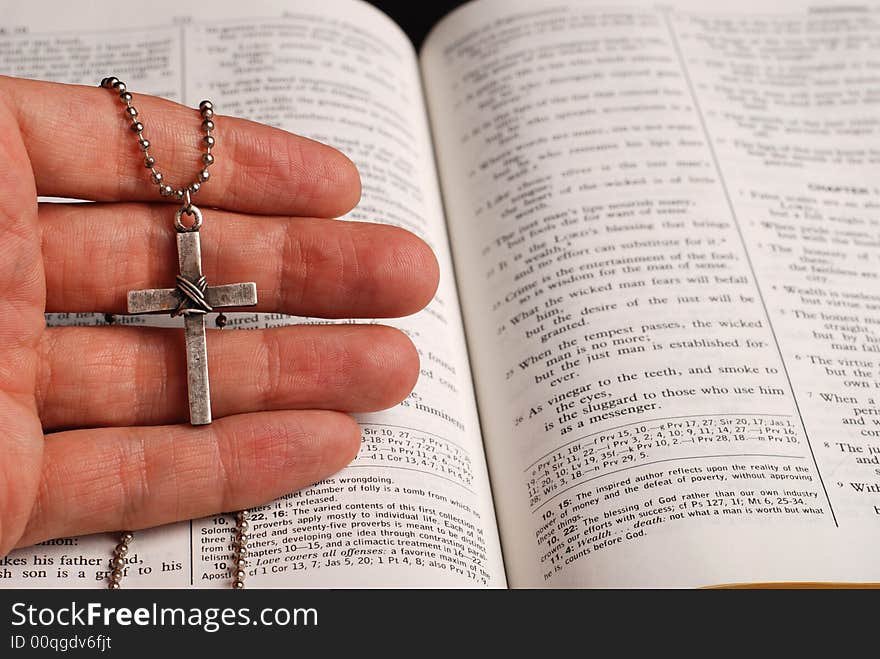 Holy bible open with a cross on a hand. Holy bible open with a cross on a hand