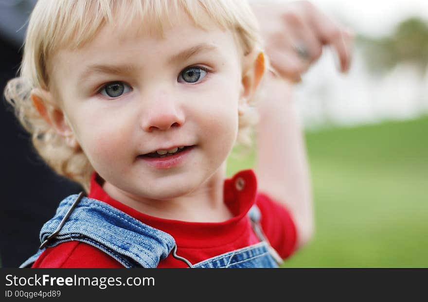 A little kid is enjoying his time in the park. A little kid is enjoying his time in the park