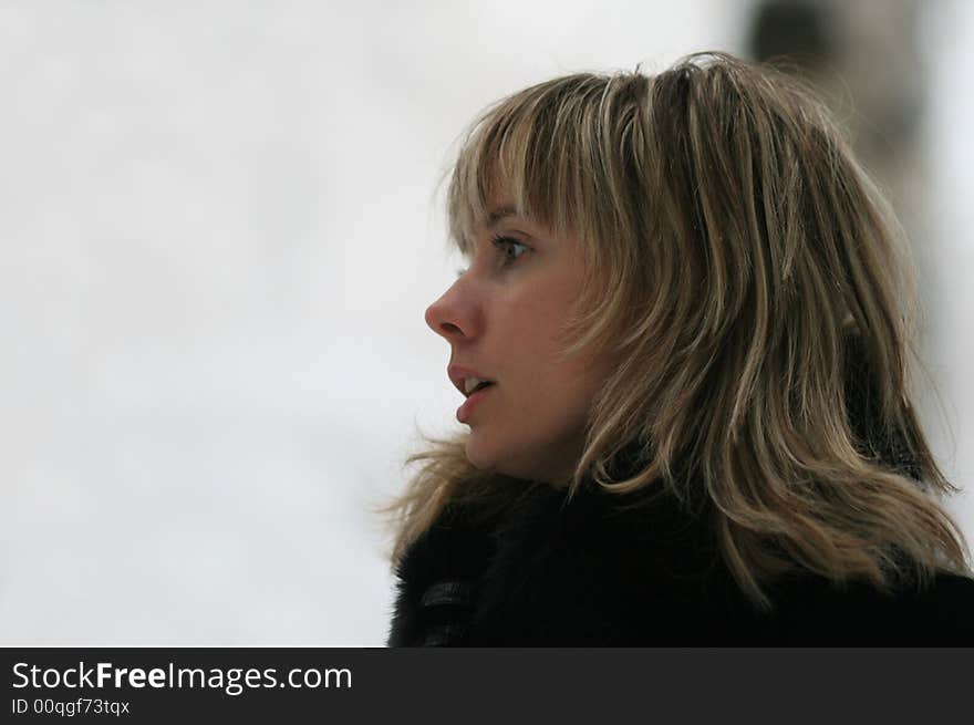 Portrait of the young smiling woman in the winter