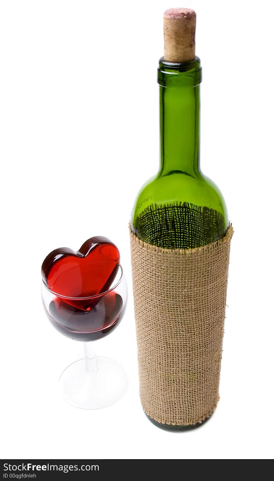 Glassy heart in a glass of wine and the bottle isolated at the white background