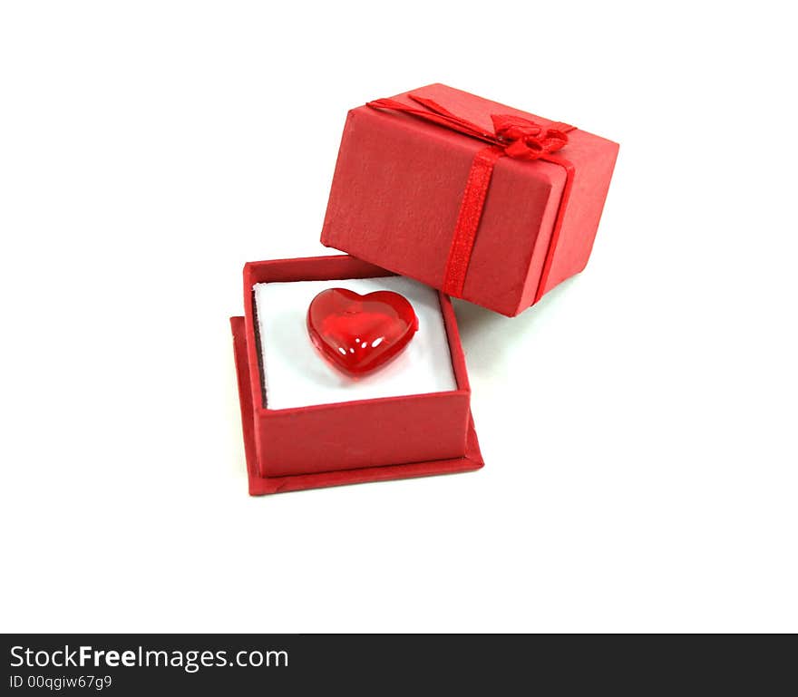 A shiny red heart shaped stone in a red gift box. Isolated on white. A shiny red heart shaped stone in a red gift box. Isolated on white.
