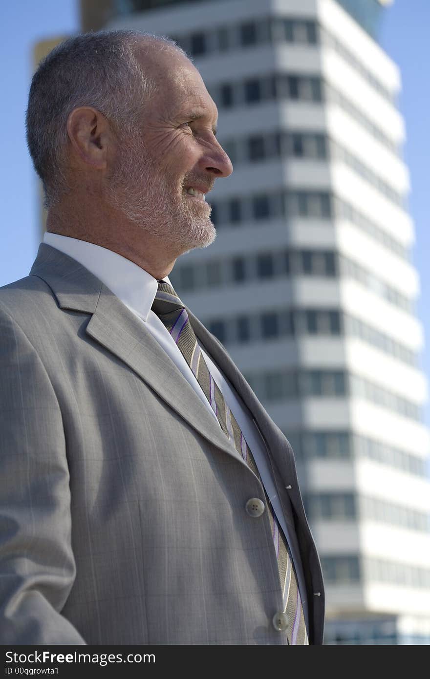 An architect on location with a building behind him