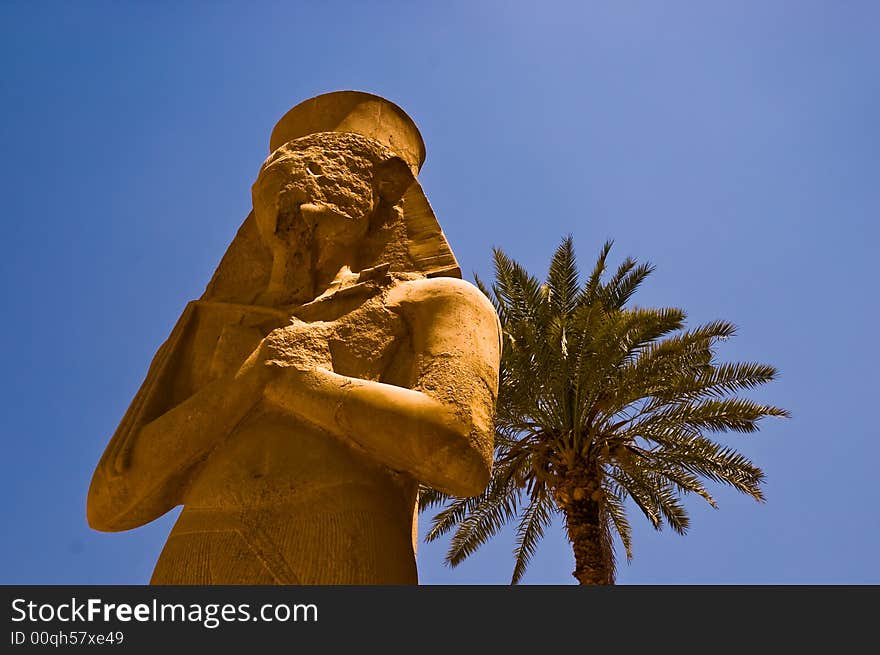 Statue of Egyptian Pharaoh with a palm tree