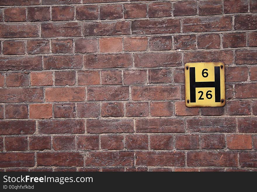 Red brick wall with yellow hydrant sign