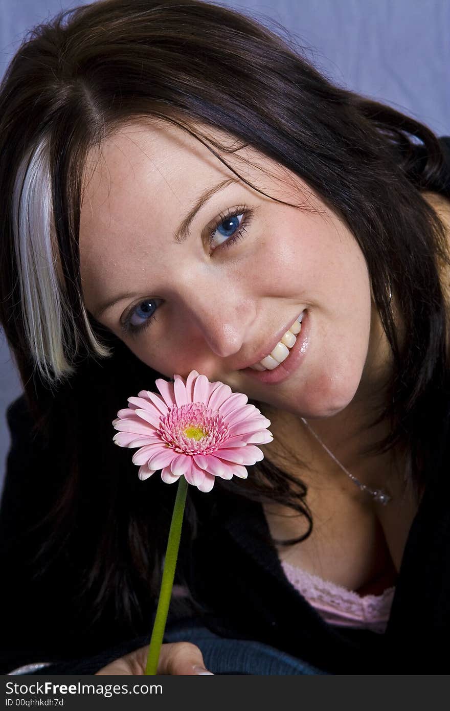 Young woman holding a pink flower