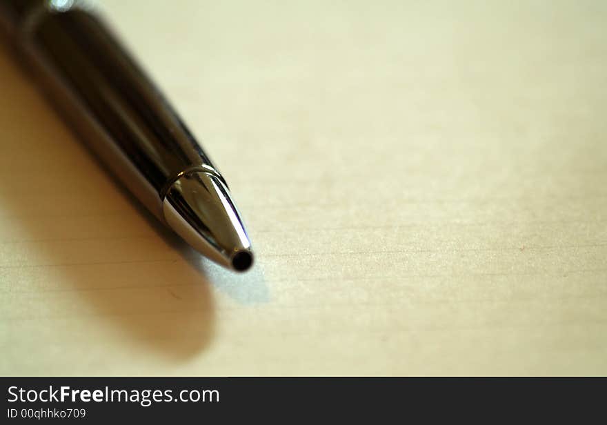 Close up Tip of elegant pen on an open notebook. Close up Tip of elegant pen on an open notebook