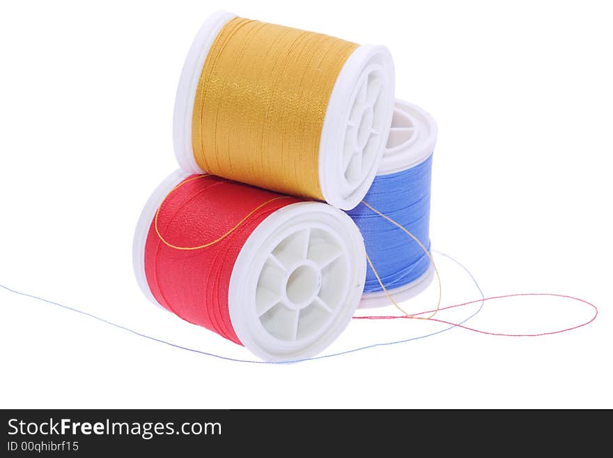 Three colored thread reels on white. Three colored thread reels on white