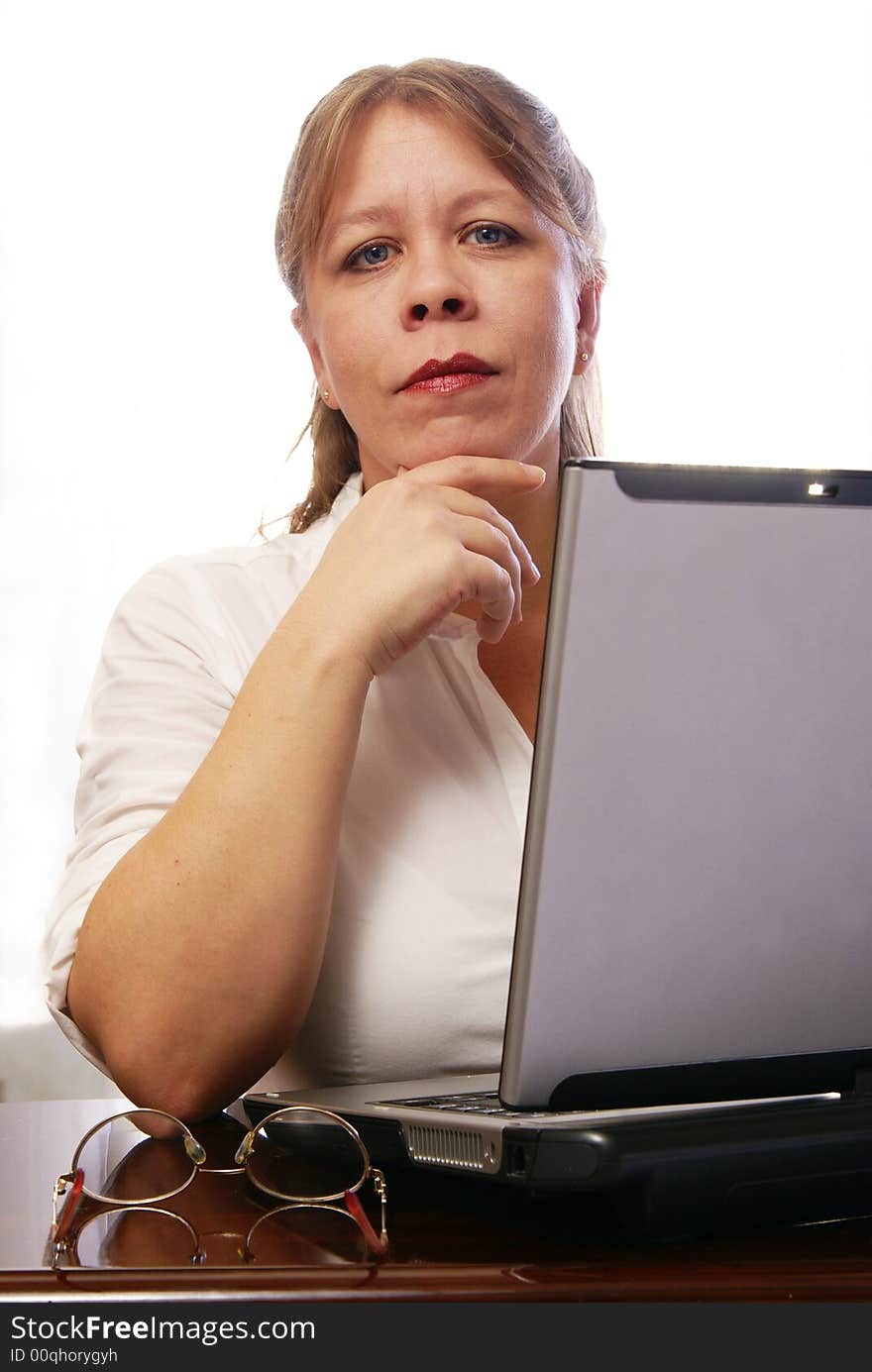 Woman in white blouse working on laptop computer. Woman in white blouse working on laptop computer