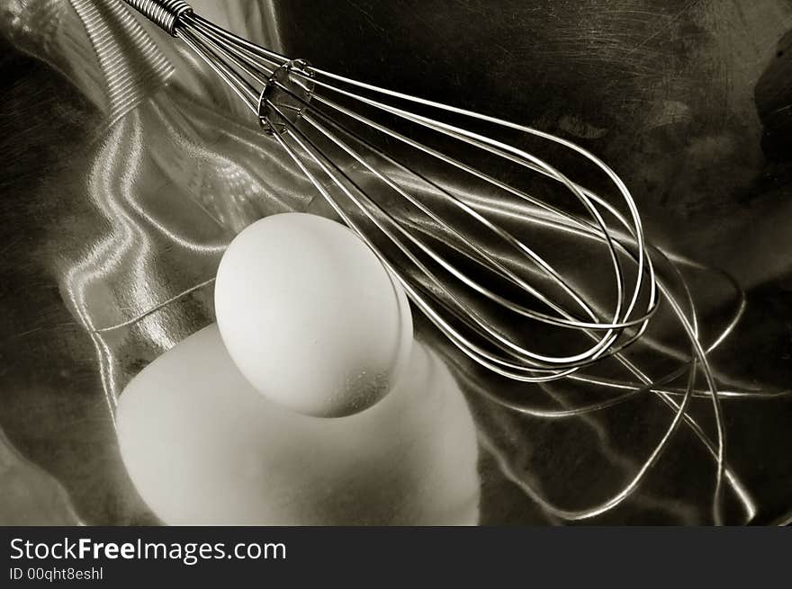 An egg reflecting in a Metal Dish with a whisk. An egg reflecting in a Metal Dish with a whisk.