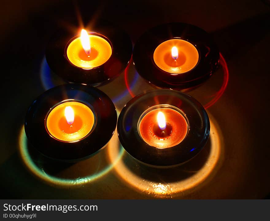 Four colored candles in glass bowls. Four colored candles in glass bowls