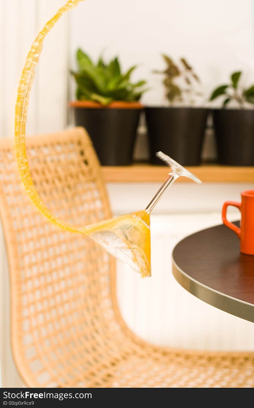 Glass falling from a table and splashing and orange beverage. Glass falling from a table and splashing and orange beverage.