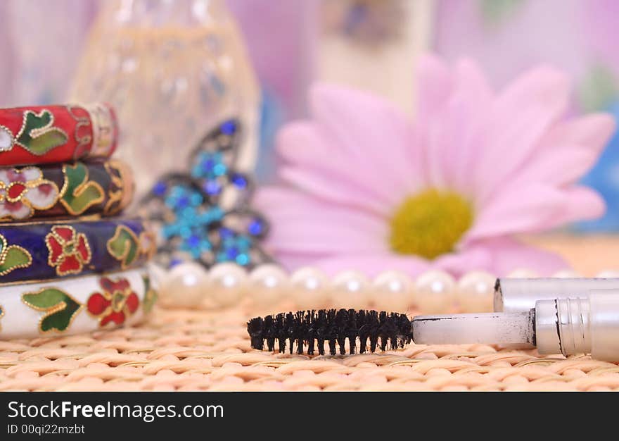 Jewelry and Mascara With Flower on Wicker  Vanity. Jewelry and Mascara With Flower on Wicker  Vanity