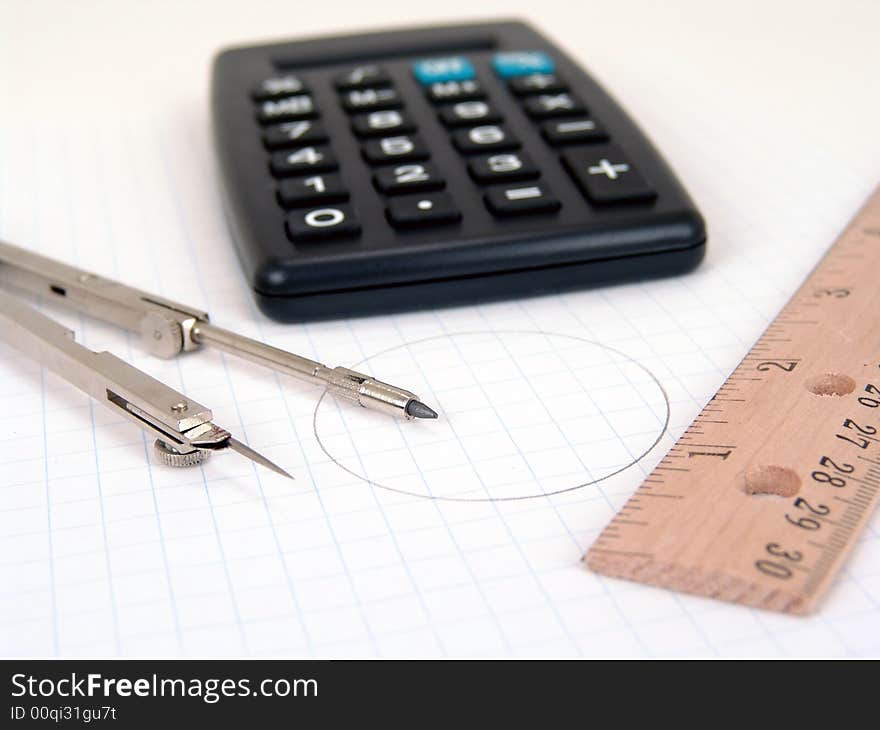 Calculator compass and ruler over graph paper. Calculator compass and ruler over graph paper