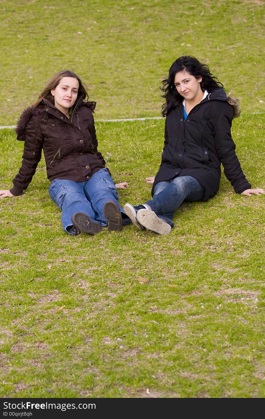 Two serene girls in the park in winter clothes