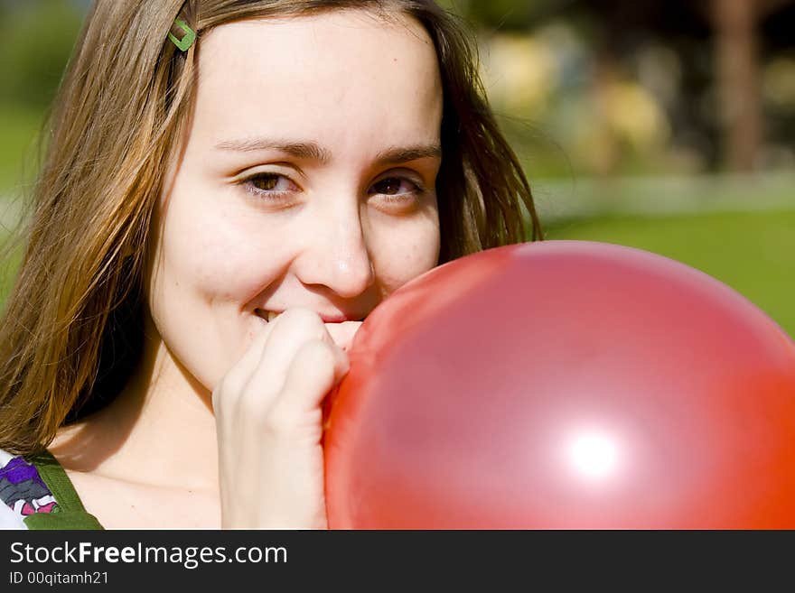 Young Woman Inflating Red Balloon